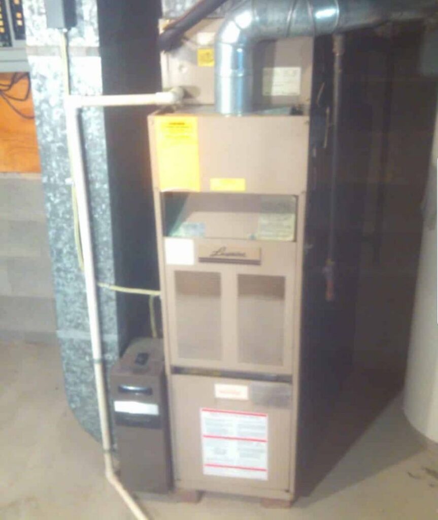 An older furnace system with ductwork and piping in a residential basement, ready for service by Northern Peak Heating & Cooling in Bozeman, MT.