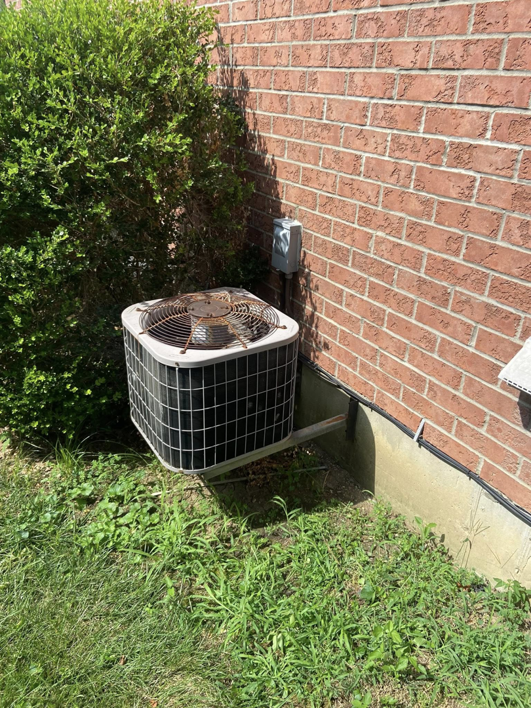 An older outdoor air conditioning condenser unit, ready for service or replacement by MK Home Services in Florence, KY.