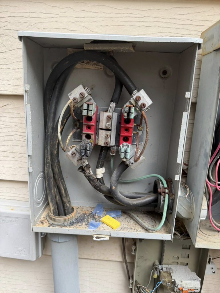 Older outdoor electrical meter base with visible wiring, serviced by Power Tech Electrical Services in Durham, NC.