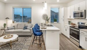 An open-concept living room and kitchen with new wood-look flooring installed by Keystone Carpet & Tile in Omaha, NE.