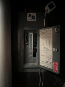 An open electrical breaker panel showing wiring and labels, serviced by Mayflower Electric LLC in Knoxville, TN