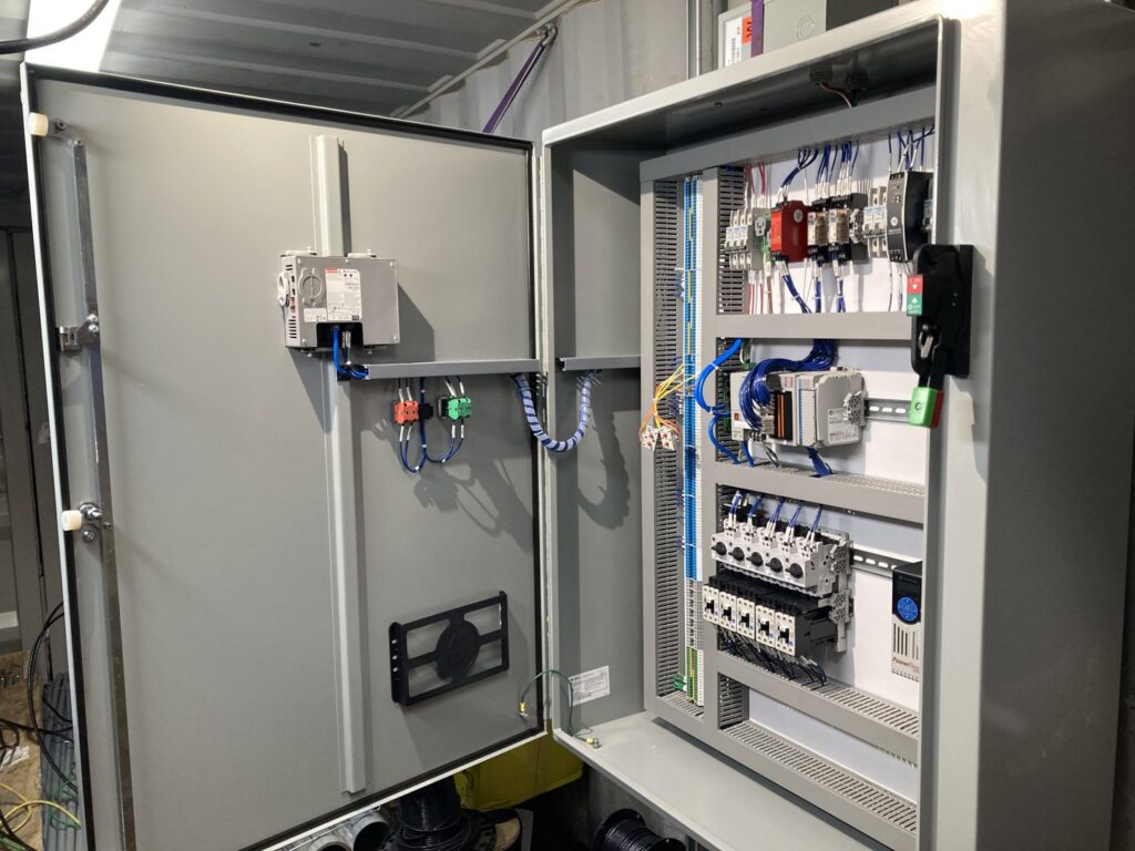 An open electrical control panel displaying intricate wiring and components, installed by BESCO in Knoxville, TN.