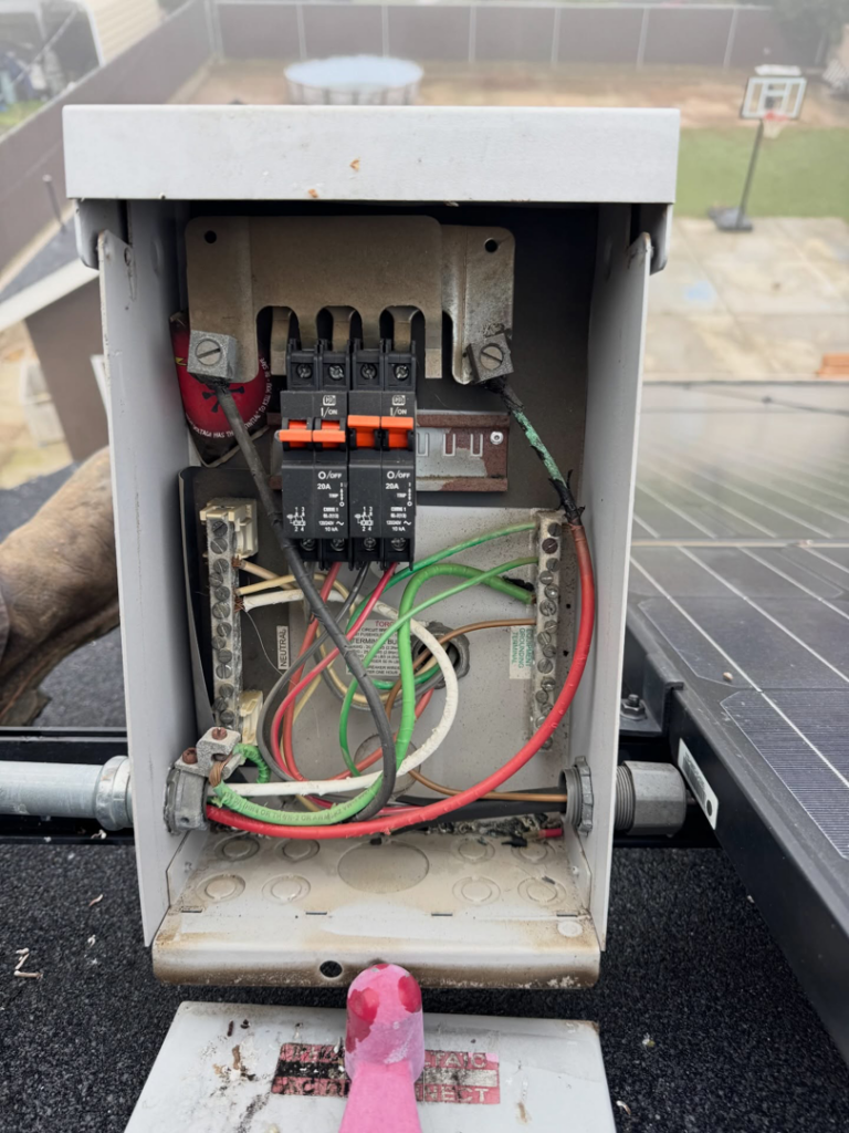 Open electrical disconnect box with wires and breakers on a roof during a solar installation by Garcia Electric Services, Bonita, CA.