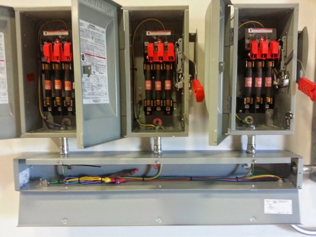 Open electrical disconnect boxes with fuses and exposed wiring, demonstrating work by Sterling Wiring Solutions in Pearland, TX.
