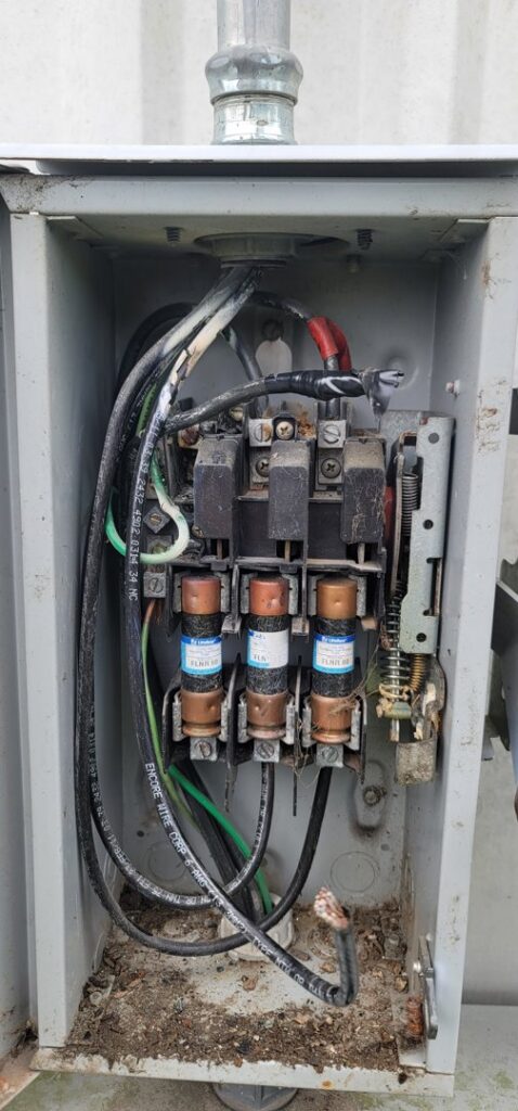 An open electrical fuse box showing fuses and wiring, indicating service by Ponce Electric in Houston, TX