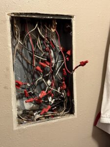 An open electrical junction box filled with wires and wire nuts, showing electrical work by Murray Electric & Plumbing in Broken Arrow, OK.