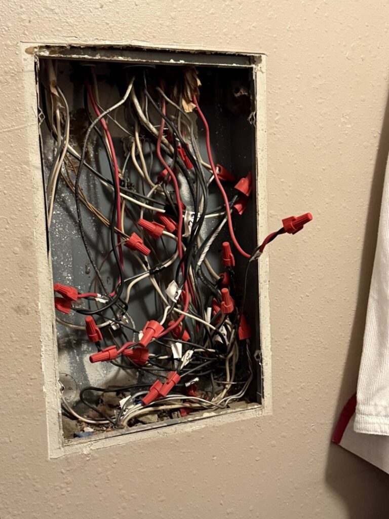 An open electrical junction box filled with wires and wire nuts, showing electrical work by Murray Electric & Plumbing in Broken Arrow, OK.