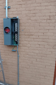 An open electrical meter combo panel installed on a brick wall by Axon Electric in El Paso, TX.