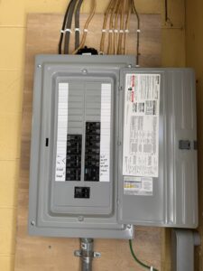 An open electrical panel or breaker box showing wiring and circuit breakers, serviced by LeBrun Electric, Heating & Cooling in Brooklyn Park, MN.