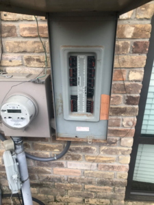 An open electrical panel showing circuit breakers on a brick wall from Pressed Down Electric LLC in Rockwall, TX.