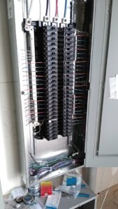 An open electrical panel showing multiple circuit breakers and wiring, indicating electrical service work by A.M.E Electrical Contracting, Inc. in Tempe, AZ.