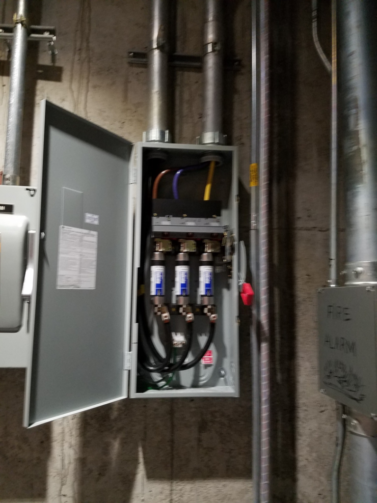 An open electrical panel showing fuses and wiring, demonstrating electrical work by Zuz Electric in Houston, TX.