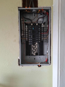 A close-up view of an open electrical panel with circuit breakers and wiring by Candid Electric in Spokane, WA.