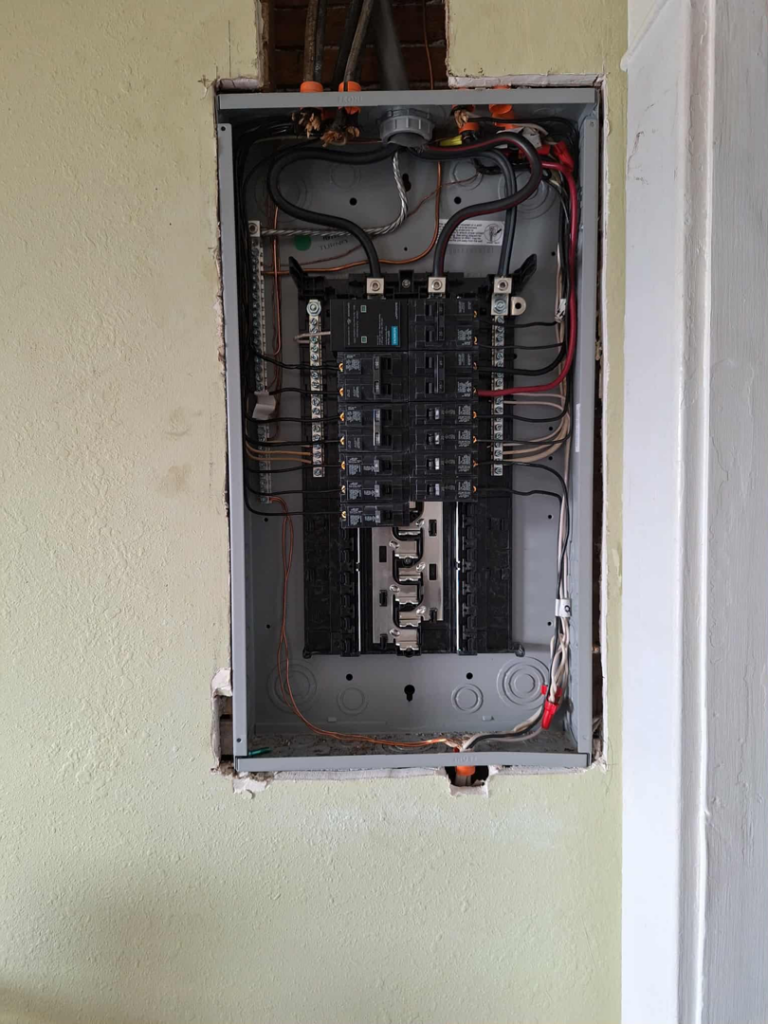 A close-up view of an open electrical panel with circuit breakers and wiring by Candid Electric in Spokane, WA.