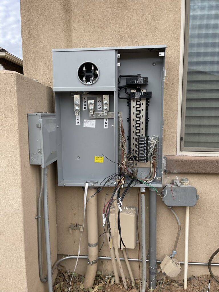 An open electrical panel showing wiring and conduit connections, serviced by EV Electric LLC in Mesa, AZ