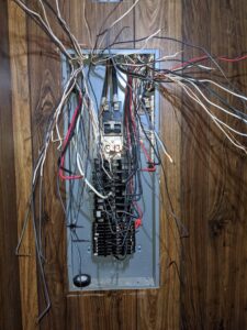 An open electrical panel with complex wiring and circuit breakers, showcasing electrical expertise by GOBE LLC in Columbia, MO.