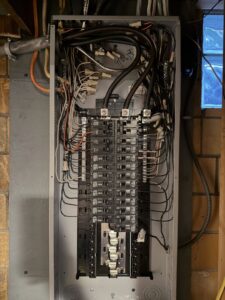 An open electrical panel showcasing detailed wiring and circuit breakers, expertly handled by Kouris Electric LLC in Canton, OH.