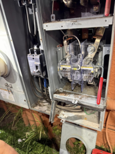 An open electrical panel with visible wiring and circuit breakers, showing an electrician's work by The GOAT Electric Company in Ft Myers, FL.