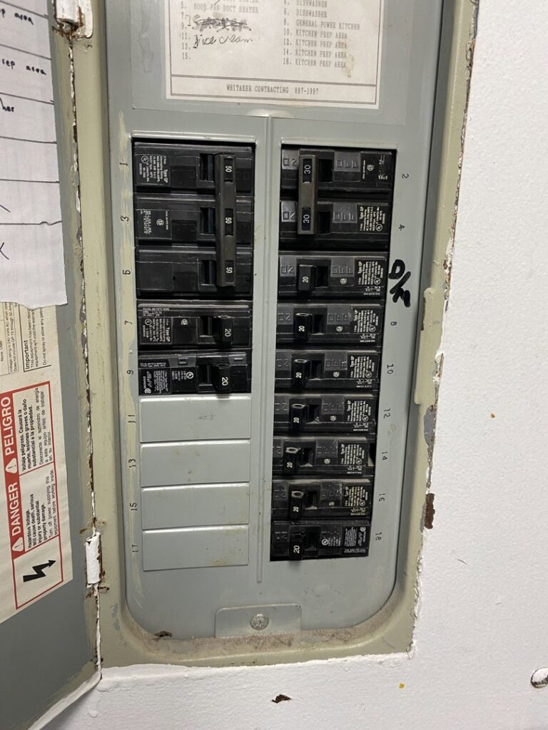 An open electrical panel displaying circuit breakers and a danger warning, indicating service by AA Electric Contractors in Chicago, IL.
