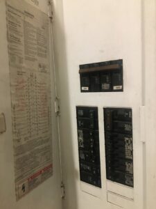 An open electrical panel with a wiring diagram on the door, serviced by Electrician Near Me in Broken Arrow, OK.