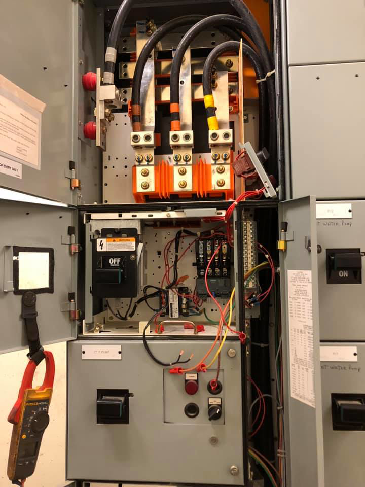 An open electrical panel showing wiring and components with a clamp meter by Desert Clark County Lighting in Las Vegas, NV.