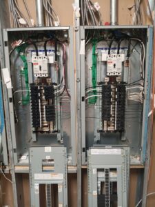 Two open electrical panels displaying circuit breakers and intricate wiring, installed by Delta Electric in Germantown, MD.