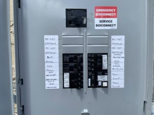 An open electrical service disconnect panel with circuit labels, indicating work by MG ELECTRIC INC in Lauderhill, FL