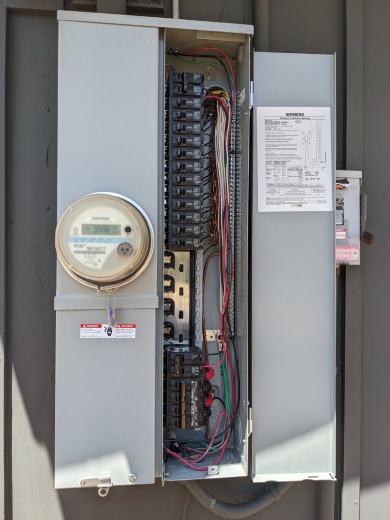 An open electrical service panel and meter on an exterior wall, indicating professional electrical work by Primo's Electrical Services in San Diego, CA.