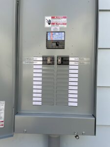 An open electrical sub-panel with circuit breakers labeled for car chargers, installed by Volt Doctors in Durham, NC