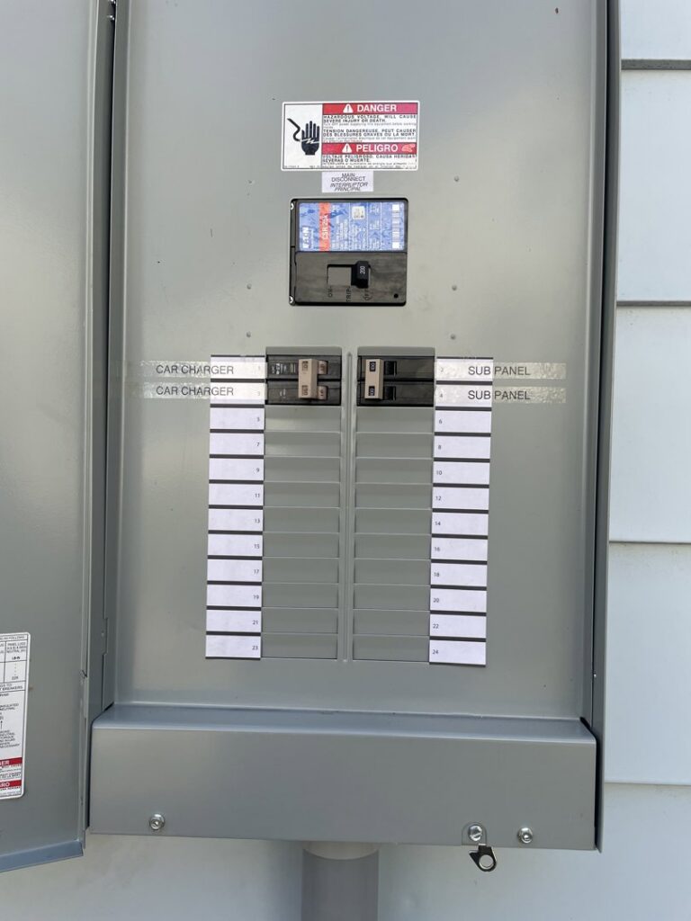 An open electrical sub-panel with circuit breakers labeled for car chargers, installed by Volt Doctors in Durham, NC