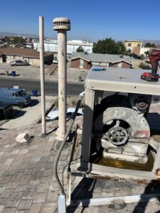 An open evaporative cooler on a roof, showing internal components during an inspection by Anchor Air in El Paso, TX