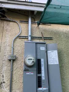 An open exterior electrical panel showing circuit breakers, indicating service by CLB Electric Corporation in Norwalk, CA