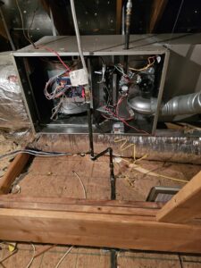 An open furnace or air handler unit in an attic, showing internal components and wiring, serviced by MasterCraft Mechanical, LLC. in Haslet, TX.