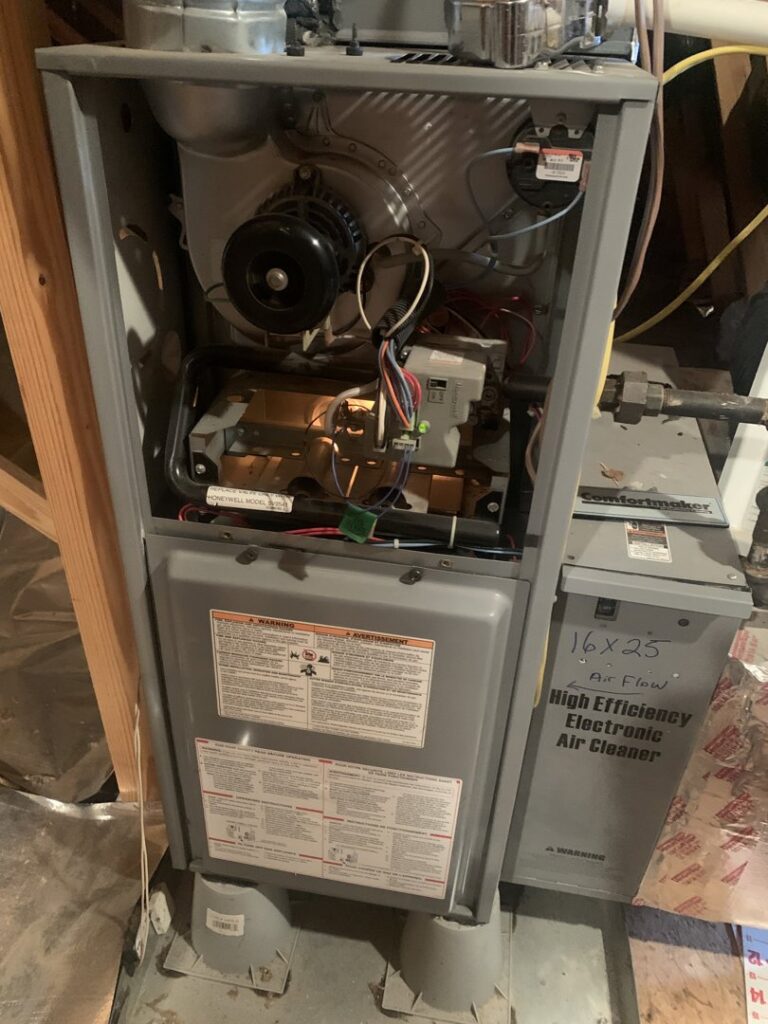 An open furnace showing internal components next to an electronic air cleaner, serviced by AVS Heating and Air Conditioning in Alexandria, VA.