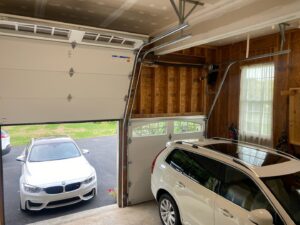 Interior view of an open garage door showing the tracks and a car, installed by Door Serv Pro in Inwood, WV.