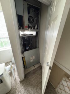 An open HVAC closet revealing a furnace or air handler with its cover removed for inspection by Direct Service HVAC & Maintenance in Lewisburg, OH.