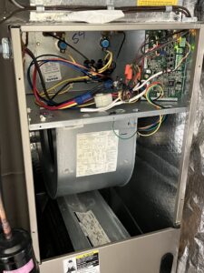 An open indoor air handler or furnace unit showing internal components, including the blower and wiring, serviced by Simply Home Service in Gaithersburg, MD.