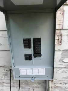 An open outdoor electrical breaker panel showing circuit breakers, serviced by Solution Electric in Houston, TX.