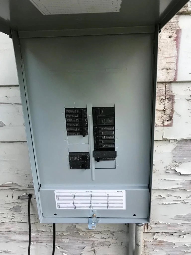 An open outdoor electrical breaker panel showing circuit breakers, serviced by Solution Electric in Houston, TX.