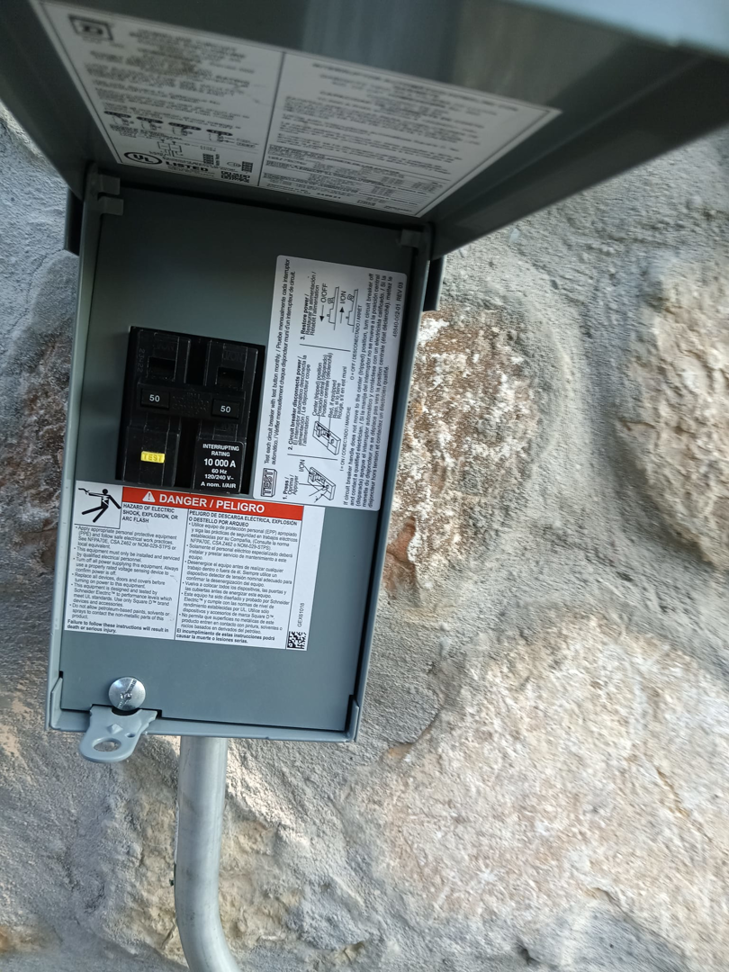 An open outdoor electrical disconnect box with a circuit breaker installed by Axon Electric in El Paso, TX.
