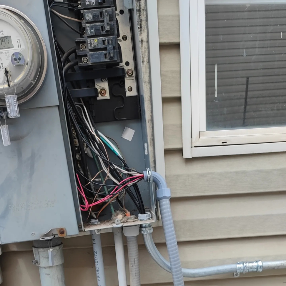 A close-up of an open outdoor electrical service panel showing wiring and breakers by Lara Electric in Miami, FL.