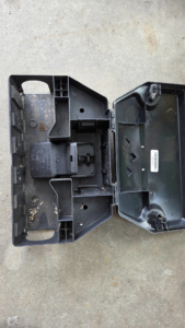 An open pest control bait station showing a snap trap inside from Armstrong's Wildlife Solutions in Rochester, NY.