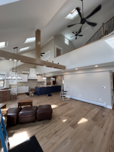 Open-plan living space with new lighting and ceiling fan installation by Nuts And Volts Electric LLC in Farmington, NH.