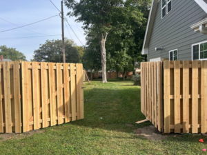 An open wood picket fence gate installed in a residential backyard by Walker Fence in Council Bluffs, IA.