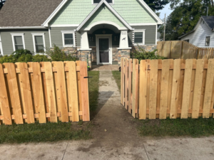 An open wood picket fence gate installed in the front yard of a house by Walker Fence in Council Bluffs, IA.
