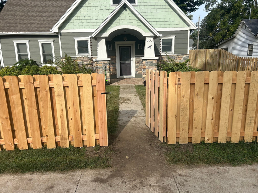 An open wood picket fence gate installed in the front yard of a house by Walker Fence in Council Bluffs, IA.