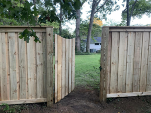 An open natural wood privacy fence gate installed by Brock Brothers Fence, leading to a backyard in Mobile, AL.