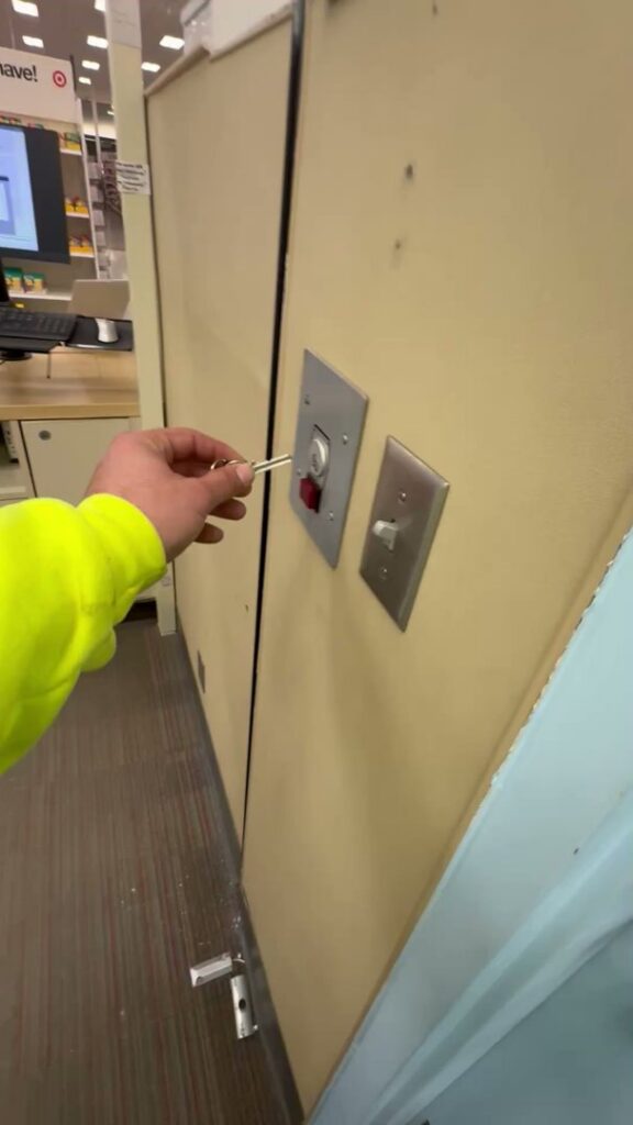 A hand operating a commercial garage door switch with a key, serviced by 405 Garage Pros in Edmond, OK.