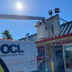 An Oregon Commercial Lighting van with a bucket lift ready for outdoor lighting service at a commercial building in Eugene, OR.
