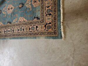 A detailed view of the edge of an ornate oriental area rug on a concrete floor by Right & Clean Atlanta 24-7 Carpet Cleaning in Atlanta, GA.